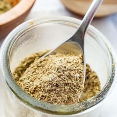 a spoon in a glass jar filled with spices