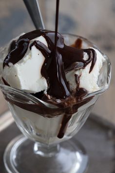 an ice cream sundae is drizzled with chocolate