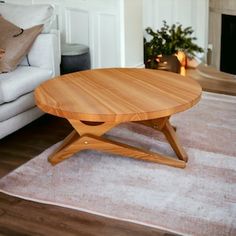 a wooden table sitting on top of a rug in front of a white couch and fireplace