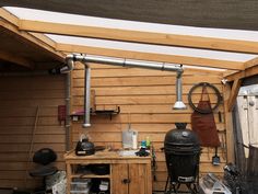 the outside of a shed with an outdoor grill and other items on it's side