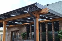 a patio covered in wood and metal furniture next to a brick building with large windows