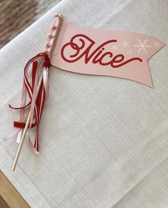 a piece of paper with the word nice on it sitting on top of a table