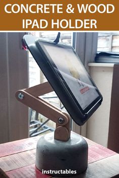 an ipad holder on top of a wooden table with text overlay that reads, how to build a concrete and wood ipad holder