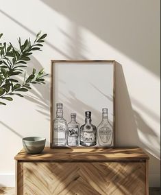 a wooden table topped with two bottles of liquor next to a potted green plant