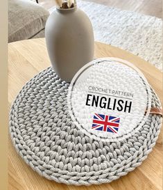 a crochet round table mat with the words english on it in front of a vase