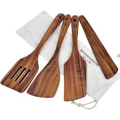 three wooden utensils sitting on top of a white cloth next to each other