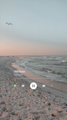 the beach is covered in sand and birds are flying over it, while the sun sets