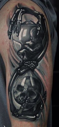 a man's arm with a black and grey tattoo on it, depicting the image of a skull in a pocket