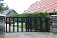 an iron gate is in front of a brick house