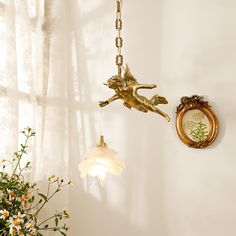 a clock hanging from the side of a wall next to a vase with flowers in it