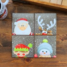 four coasters decorated with christmas images on wood table next to coffee cup and mug