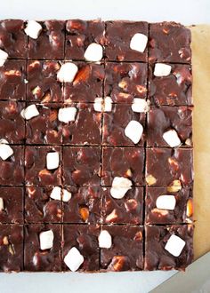 a cutting board topped with brownies covered in marshmallows