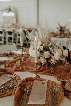 the table is set with silverware and flowers