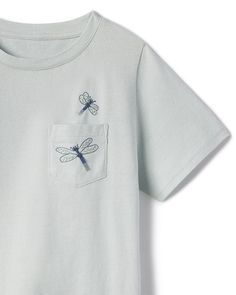 In 100% super soft cotton jersey, the Billy will be your boys (and your) favorite go-to t-shirt. The multi-color dragonfly embroidery pairs perfectly with our Botanical by Inslee Fariss collaboration print for women and girls. They flutter across the pocket giving a sophisticated yet sweet nod the fun print. Product Details 100% cotton Functional pocket at wearer's left chest Novelty dragonfly embroidery detail on and above pocket Care Machine wash cold with like colors Lay flat to dry Steam or Dragonfly Inspired Fashion, Dragonfly Bleach Shirt, Dragonfly Clothing, Inslee Fariss, Embroidered Dragonfly, Dragonfly Embroidery, Dragonfly Tshirt, Billy T, Spring Tops