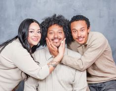 three people are posing for the camera with their arms around each other and smiling at the camera