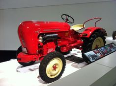 an old red tractor on display in a museum