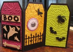 three halloween treat boxes sitting on top of a wooden table with bats and spider webs