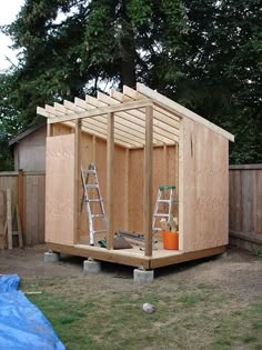 a small wooden shed sitting in the middle of a yard