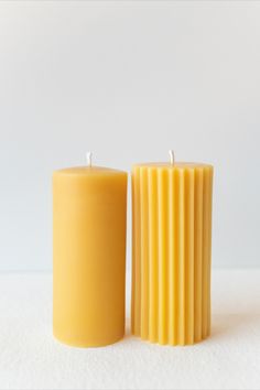 two yellow candles sitting next to each other