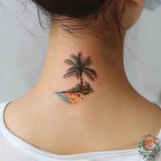 a woman's neck with a small palm tree on it