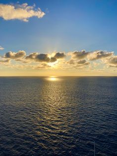 the sun is setting over the ocean as seen from a ship in the middle of the ocean