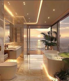 a bathroom with a large bathtub next to a sink and a toilet in front of a window overlooking the ocean