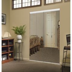 an open door leading to a bedroom with a bed in the corner and a potted plant next to it