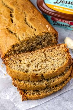 sliced loaf of banana bread next to a container of peanut butter