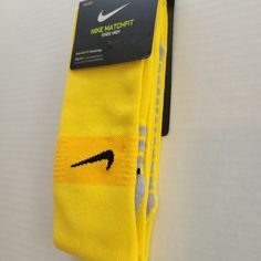 a pair of yellow nike socks sitting on top of a white table next to a card