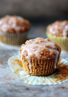 two muffins with icing on top of a paper plate