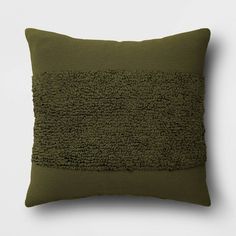 a green pillow on a white wall with a black border around the bottom and side