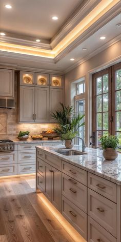 a large kitchen with wooden floors and white cabinetry is lit by recessed lighting