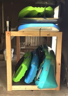 there are many surfboards on the rack in this garage, and one is green