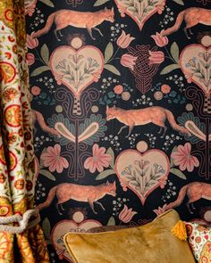 a chair sitting in front of a wallpapered with animals and flowers on it