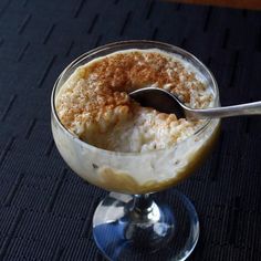 a dessert in a glass bowl with a spoon