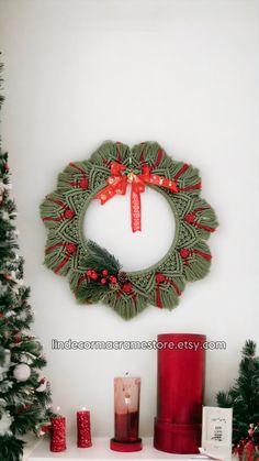 a christmas wreath is hanging on the wall above a mantle with candles and other holiday decorations