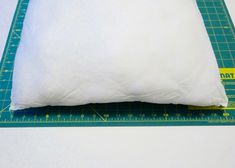 a white pillow sitting on top of a green ruler