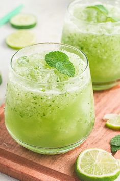 two glasses filled with limeade on top of a wooden cutting board