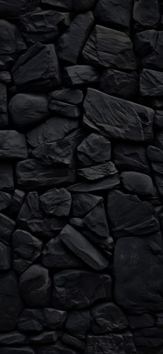 a black rock wall with lots of rocks on it