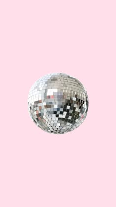 a silver disco ball on a pink background