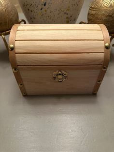 a wooden box sitting on top of a table next to vases and other items