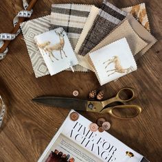 scissors, tape and other sewing supplies on a wooden table next to some fabric samples