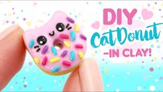 a hand holding a pink doughnut with sprinkles on it and the words diy cat donut in clay