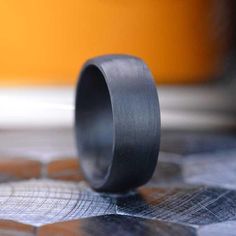 a black ring sitting on top of a wooden table