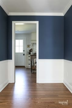 an empty room with blue walls and white trim