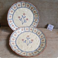 two blue and white plates sitting on top of a table next to each other,