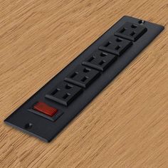 a wooden table with a black and red light switch plate on top of it's side