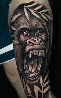 a man's arm with a gorilla on it and leaves around his neck, in black and grey