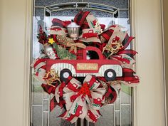 a red truck decorated with burlocks and bows is hanging on the front door