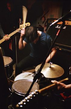 a man sitting in front of a drum set